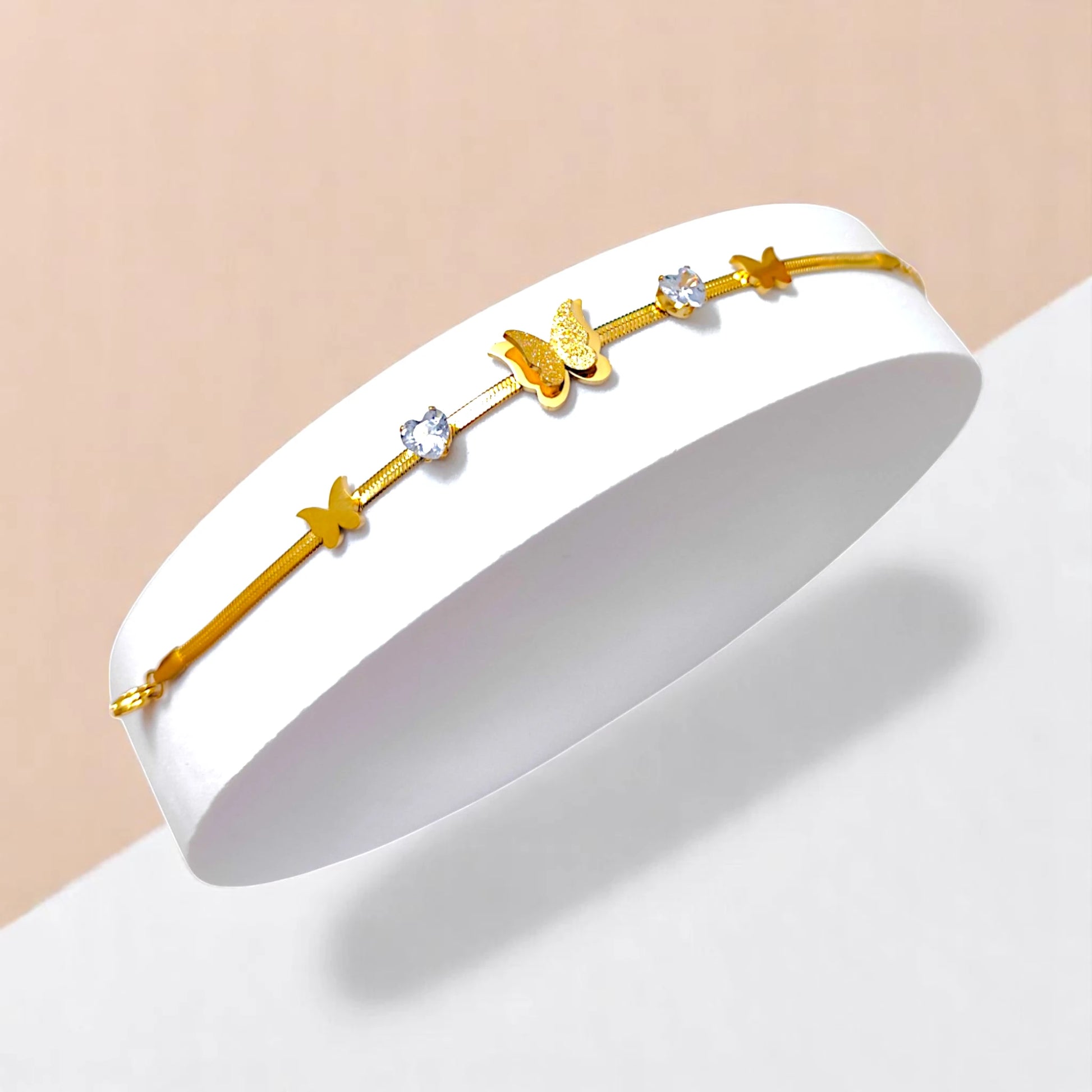 Bracelet on geometric prop with white and peach color gradient in the background.