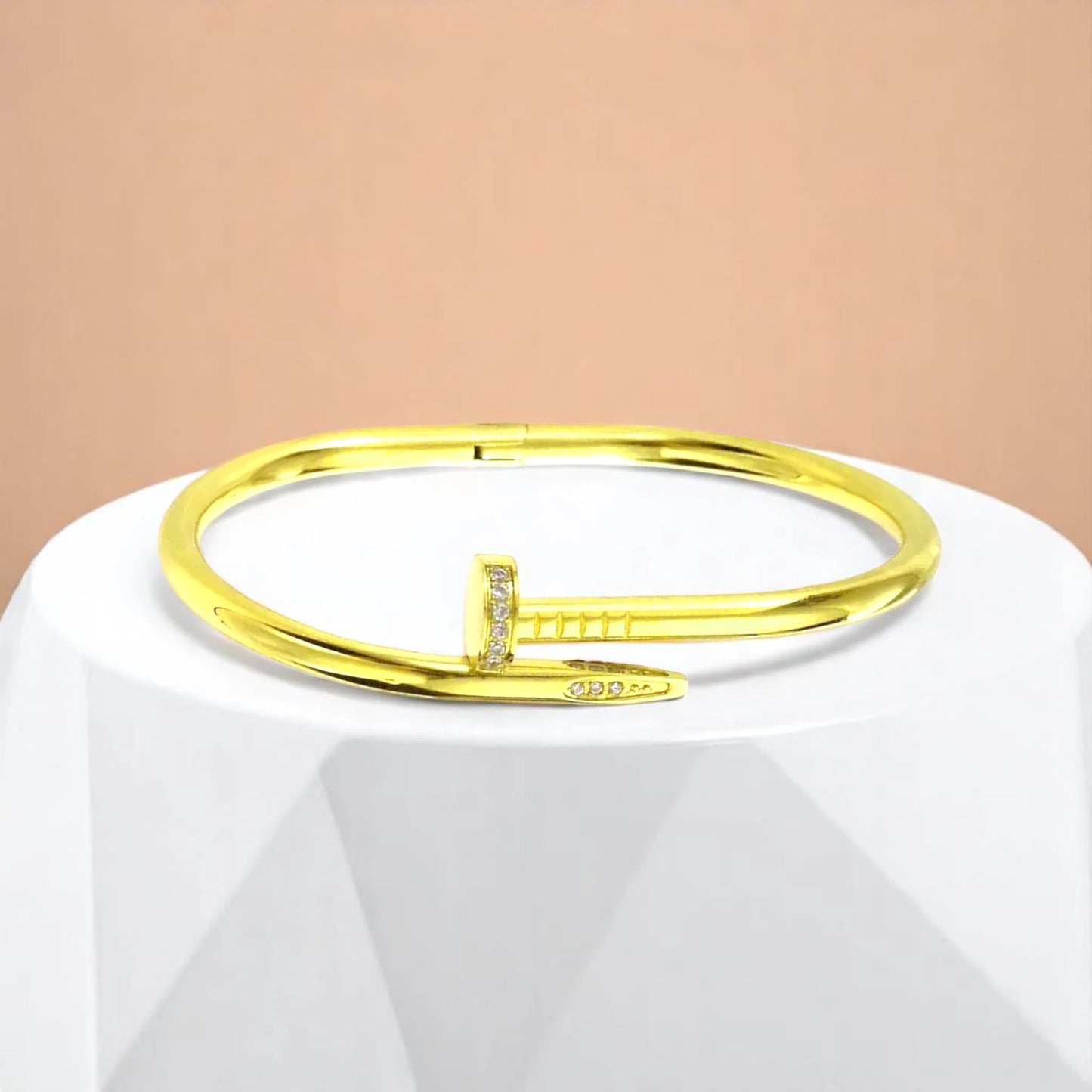 Bracelet on geometric prop with peach color gradient in the background