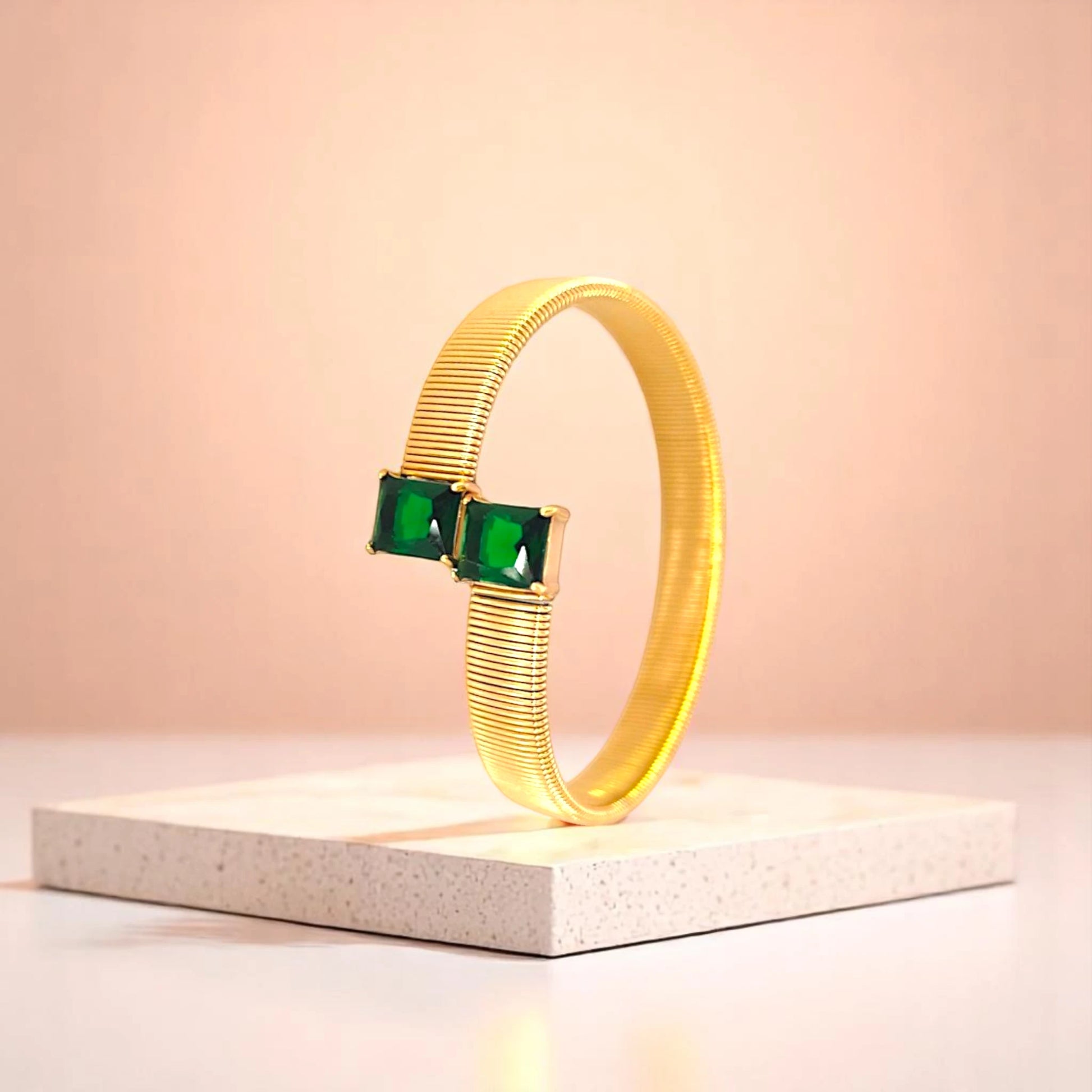 Bracelet on geometric prop with peach color gradient in the background.