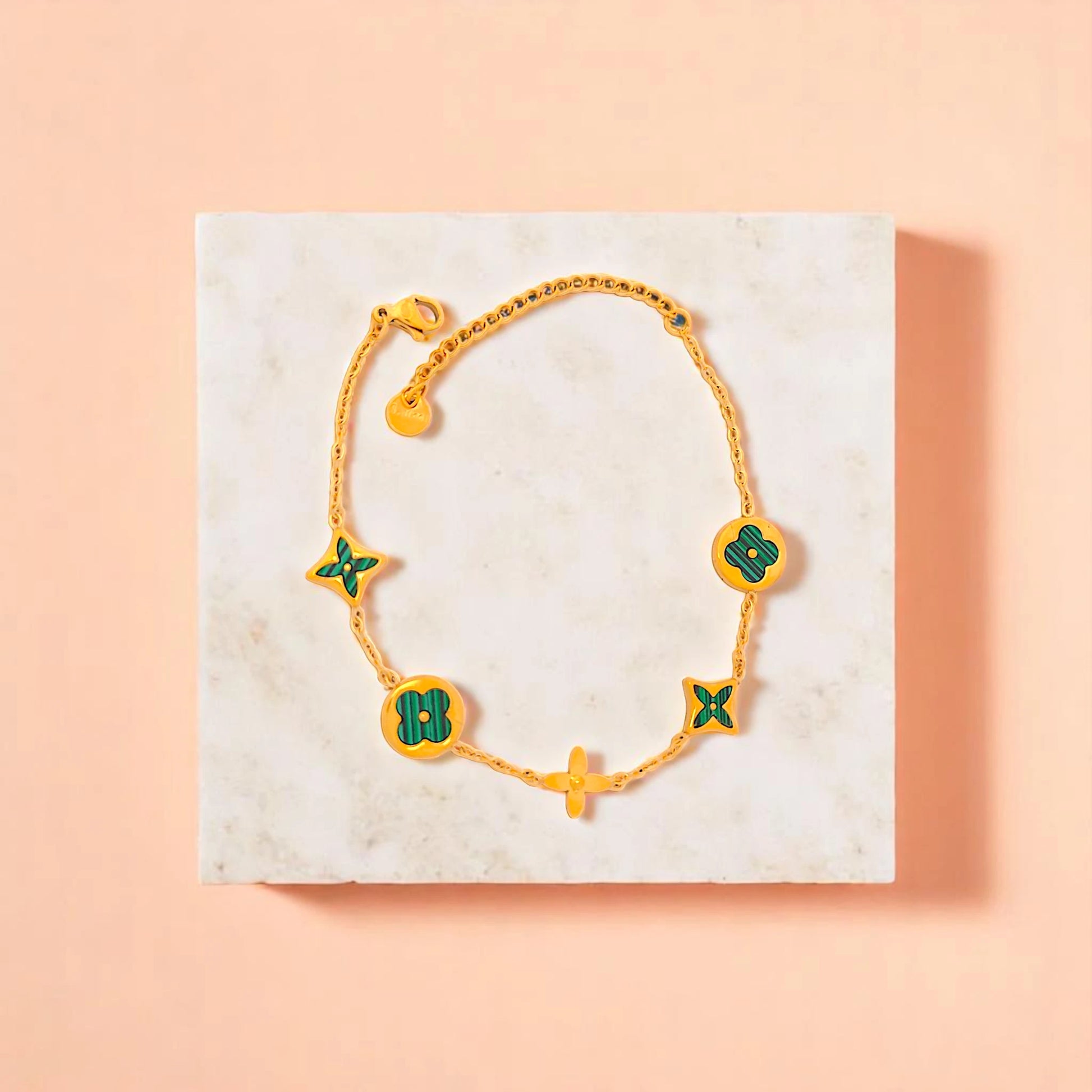 Bracelet on geometric prop with peach color gradient in the background.