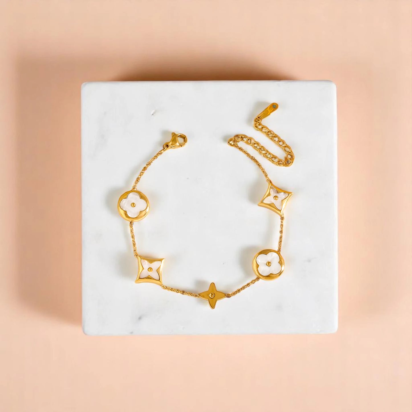 Bracelet on geometric prop with peach color gradient in the background.