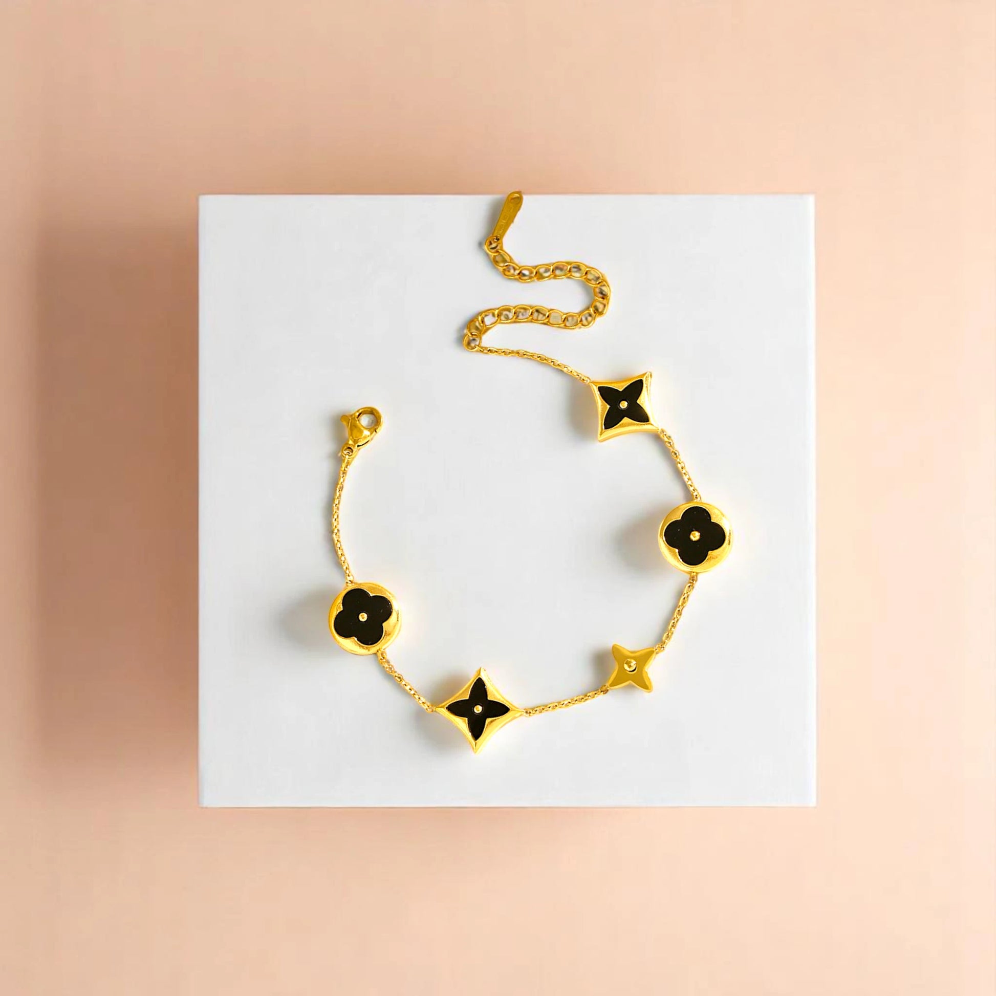 Bracelet on geometric prop with peach color gradient in the background.