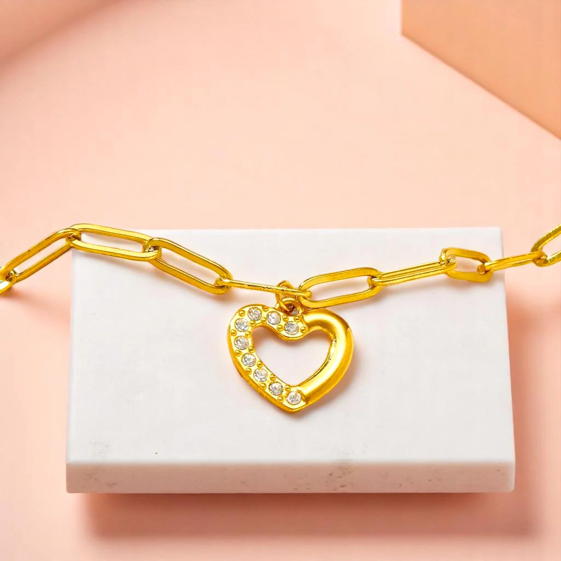 Bracelet on geometric prop with peach color gradient in the background.