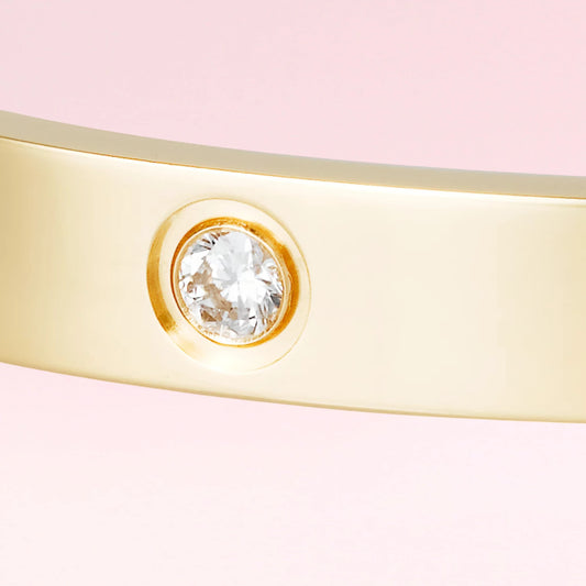 Crystal setting close-up on a bracelet on a color gradient of light tones background.