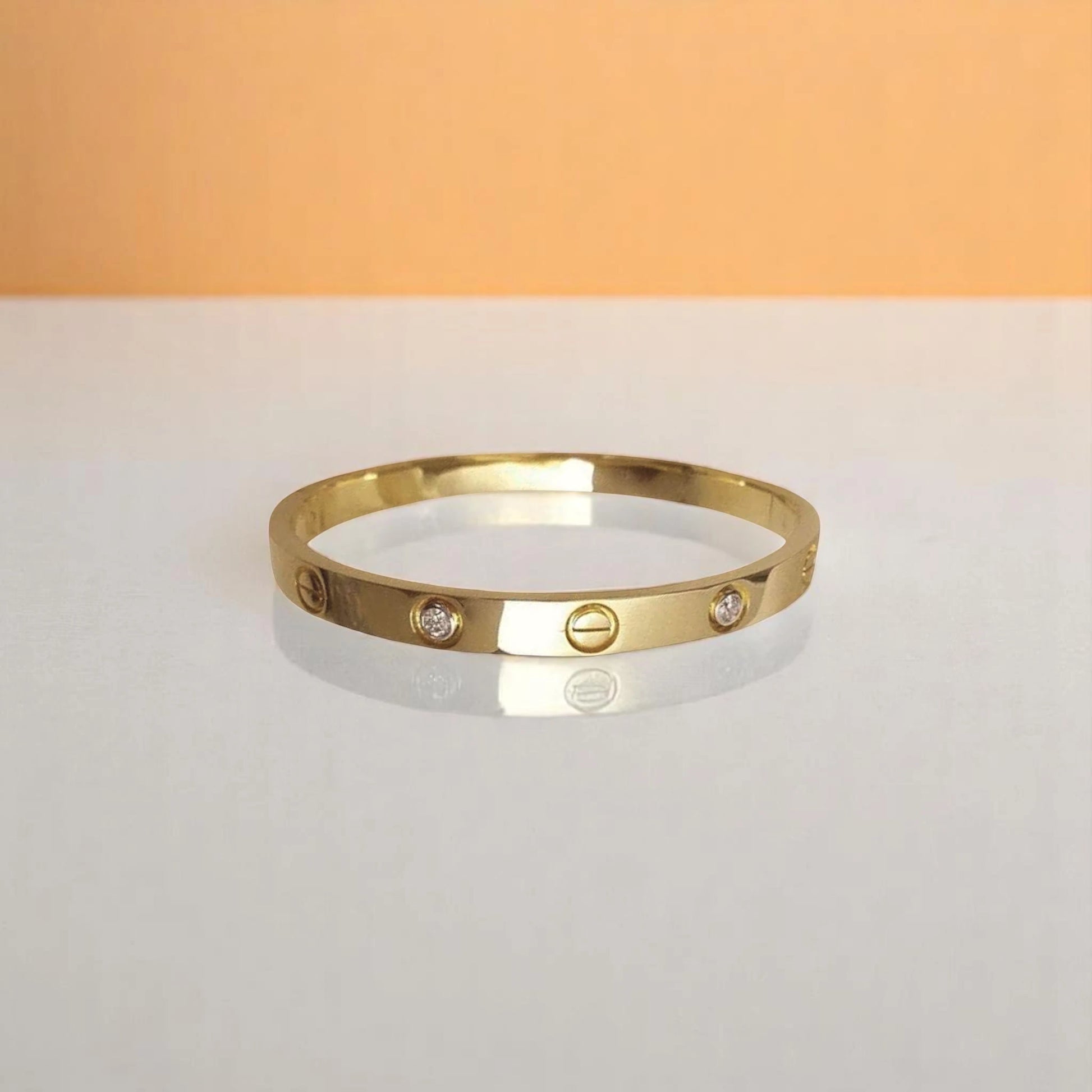 Bracelet on geometric prop with peach color gradient in the background.