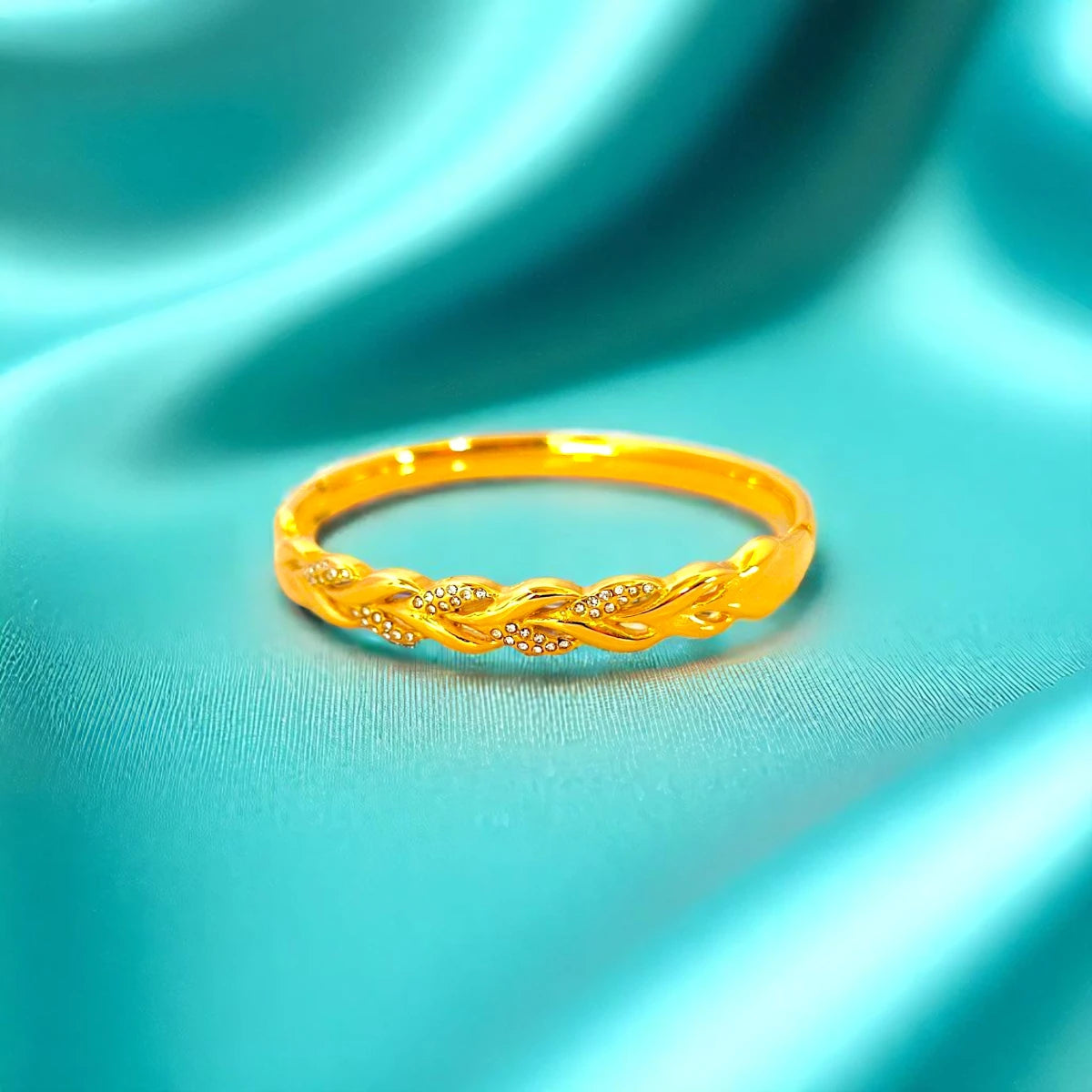 Bracelet set against a soft teal cloth background.