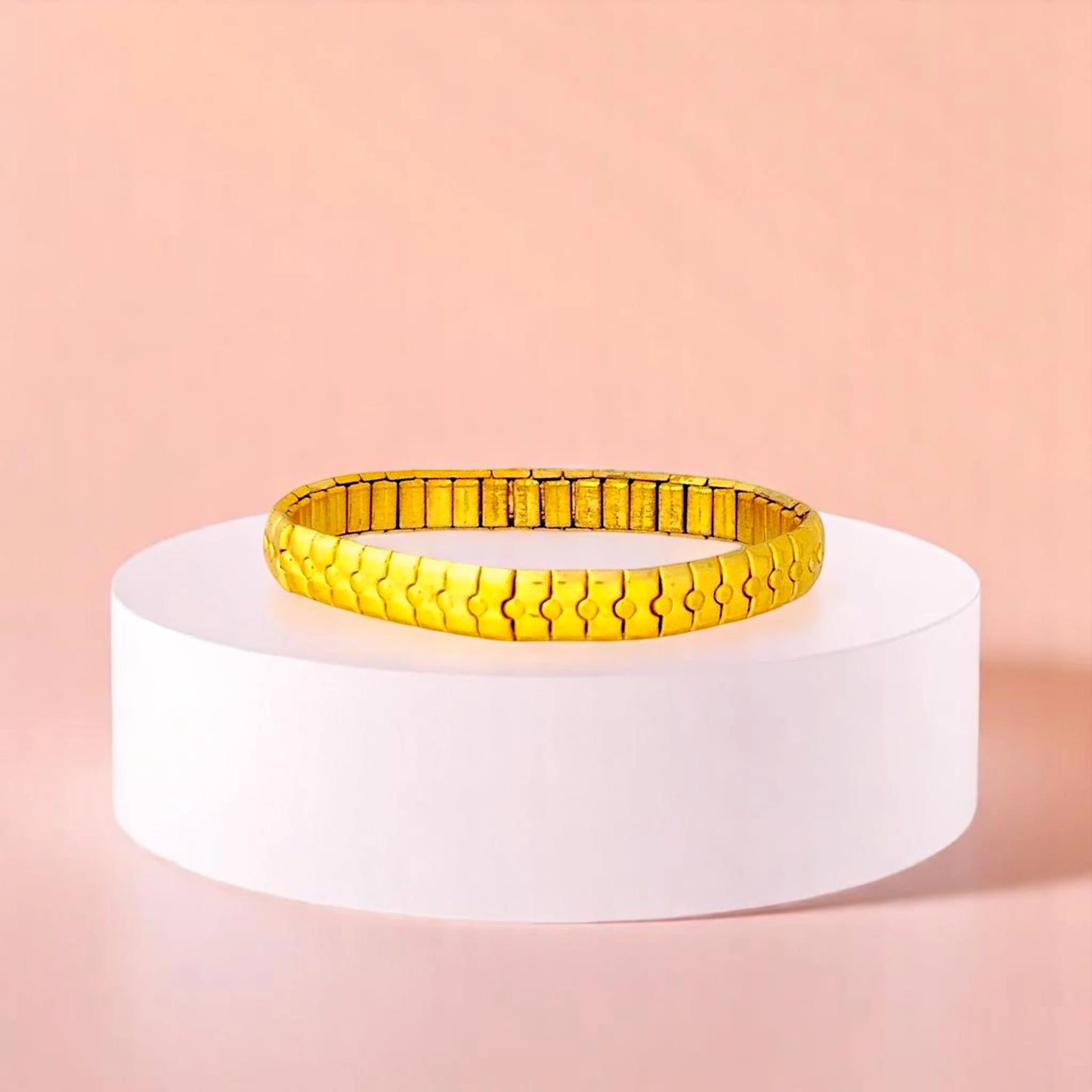 Bracelet on geometric prop with peach color gradient in the background.