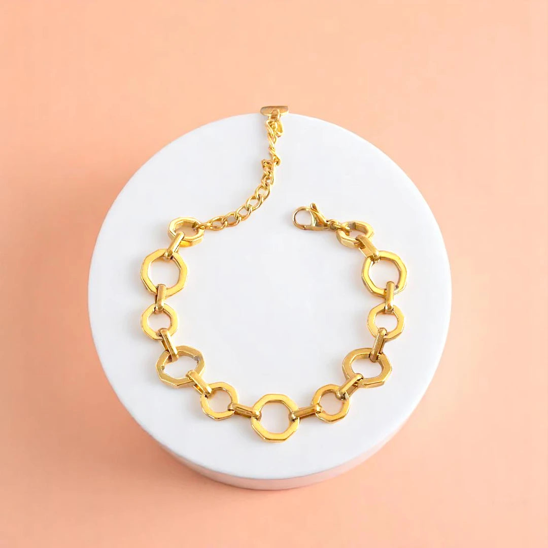 Bracelet on geometric prop with peach color gradient in the background.