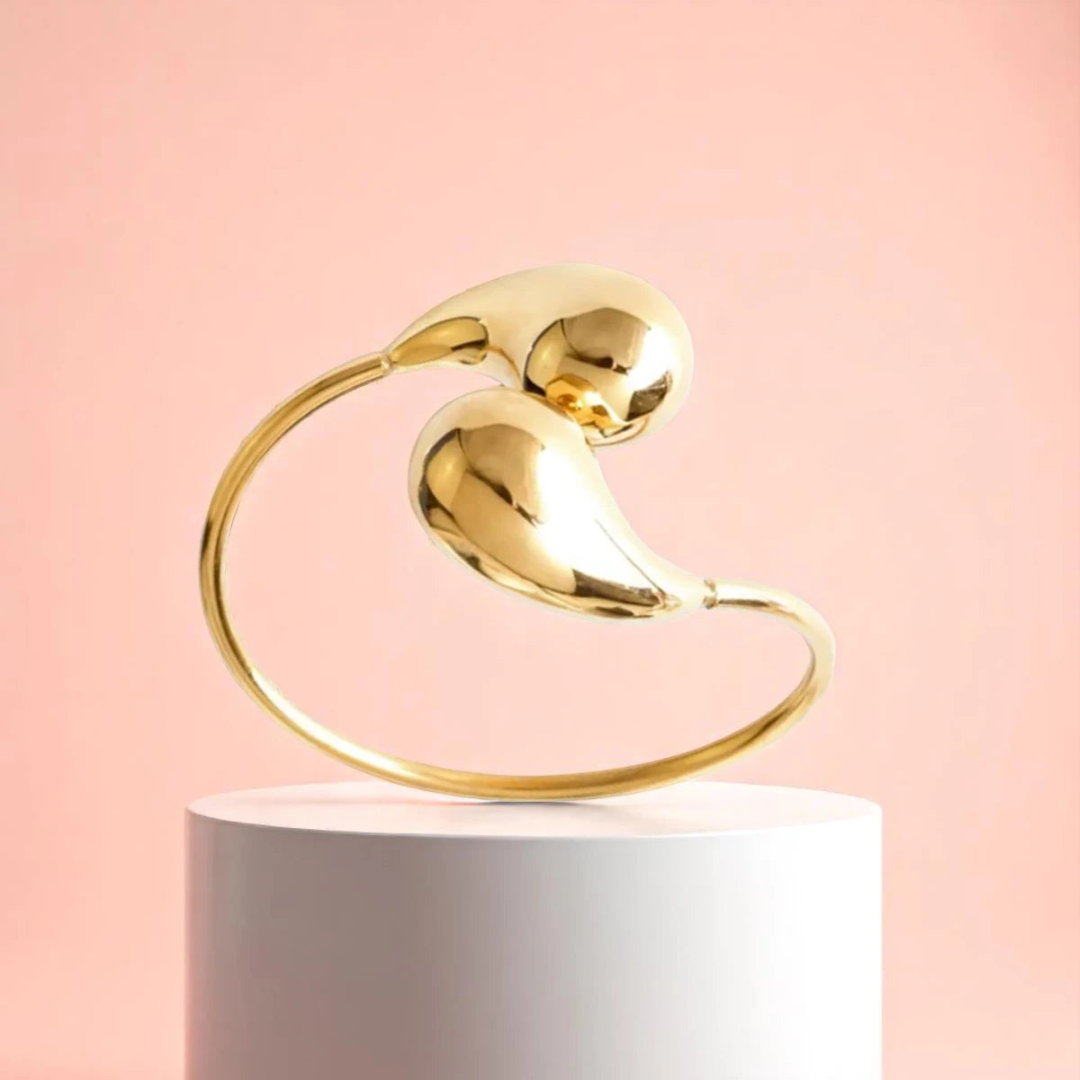 Bracelet displayed on a white pedestal against a soft peach background.