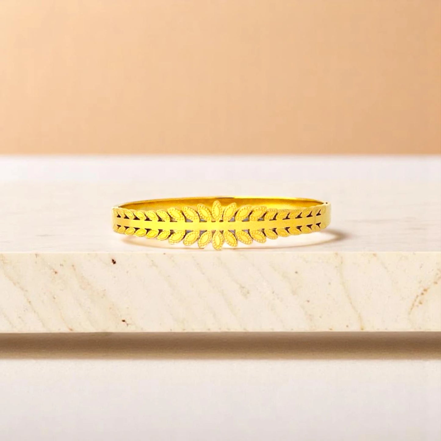 Bracelet on geometric prop with peach color gradient in the background.