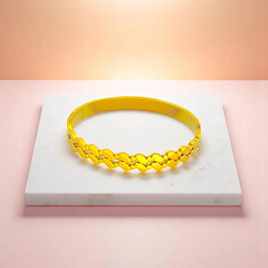 Bracelet on geometric prop with peach color gradient in the background.