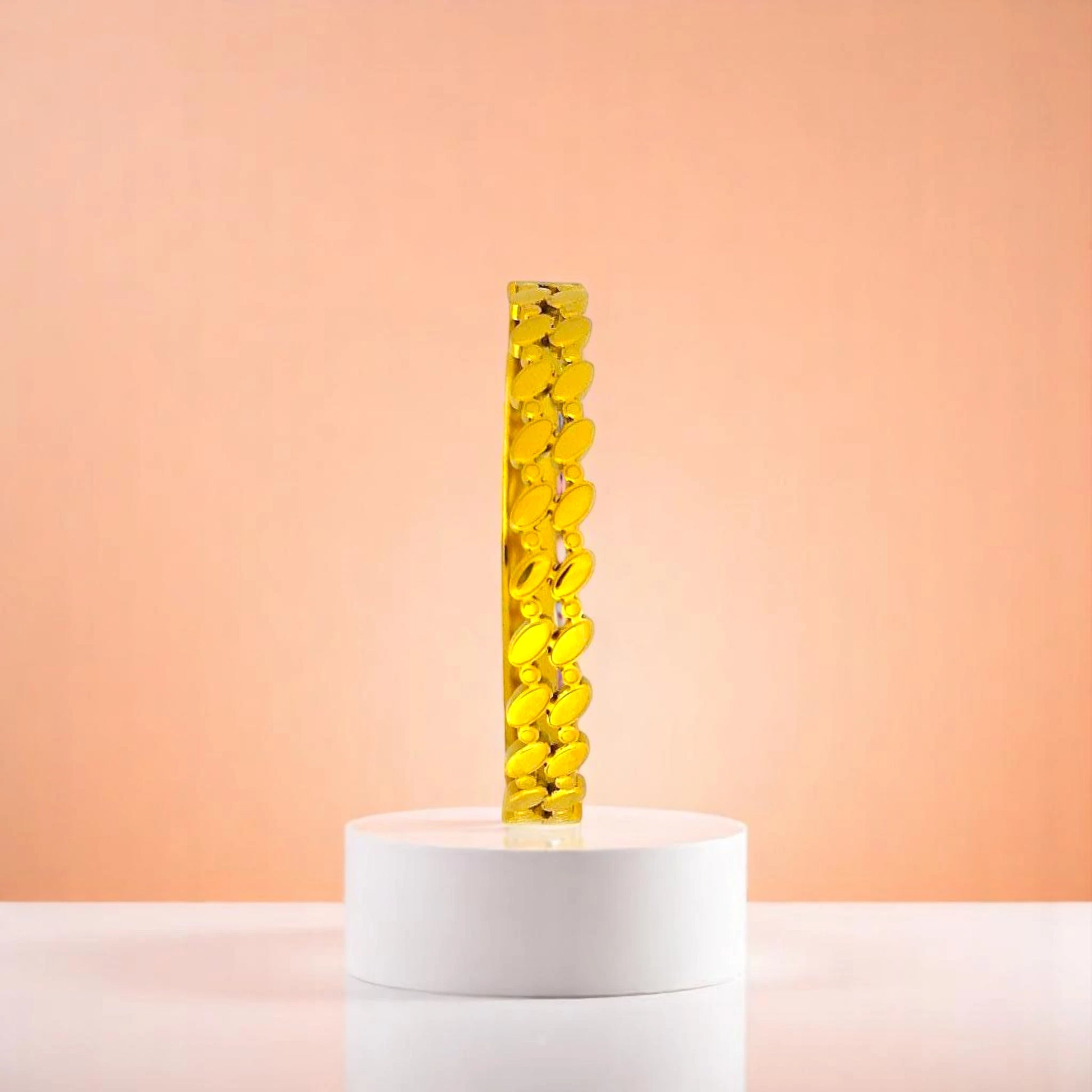 Bracelet on geometric prop with peach color gradient in the background.