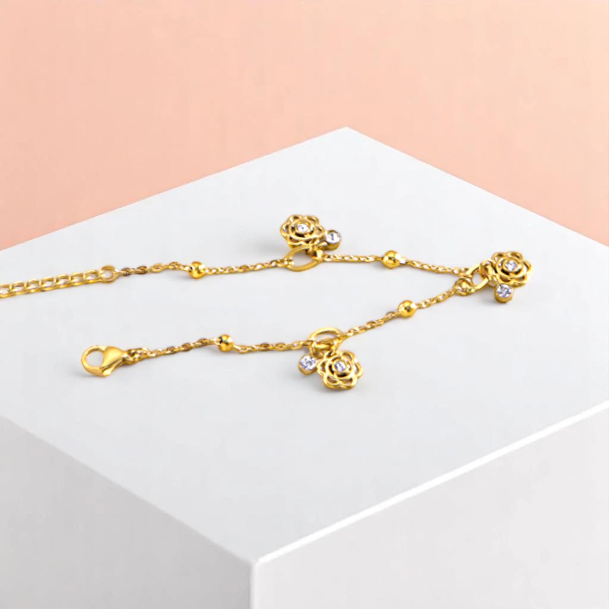 Bracelet on geometric prop with peach color gradient in the background.