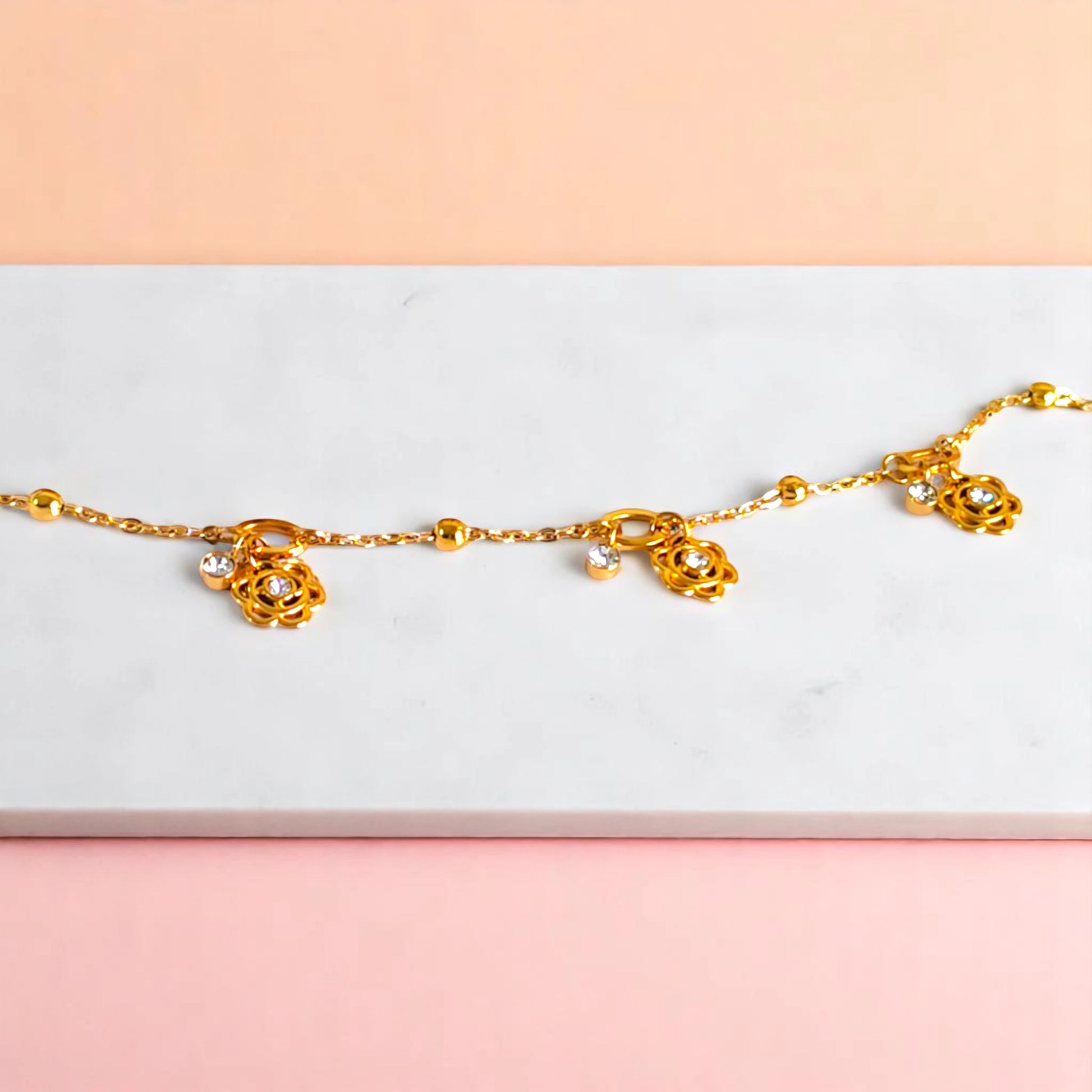 Bracelet on geometric prop with peach color gradient in the background.