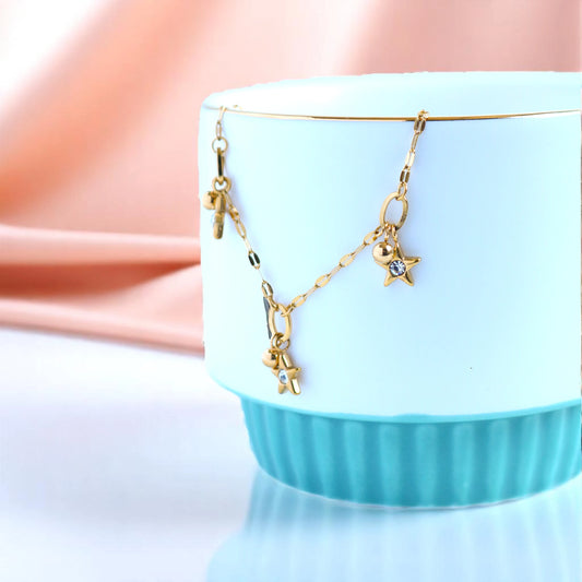 Bracelet rests on a light blue cup against a soft pink backdrop.