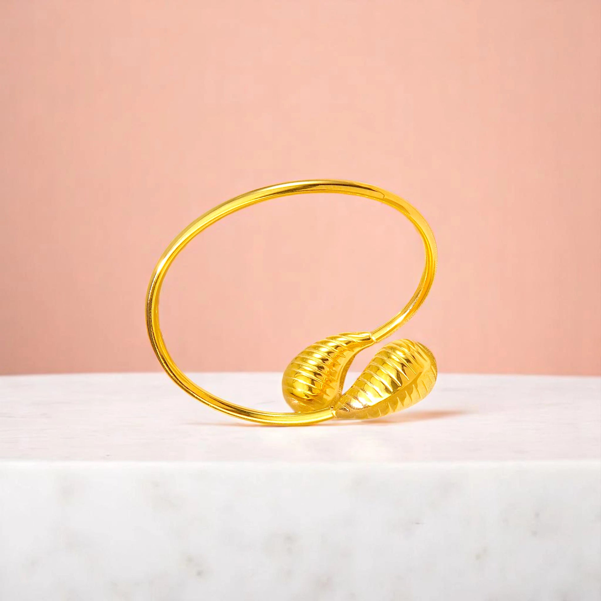 Bracelet on geometric prop with peach color gradient in the background.