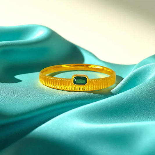 Bracelet set against a soft teal cloth background.