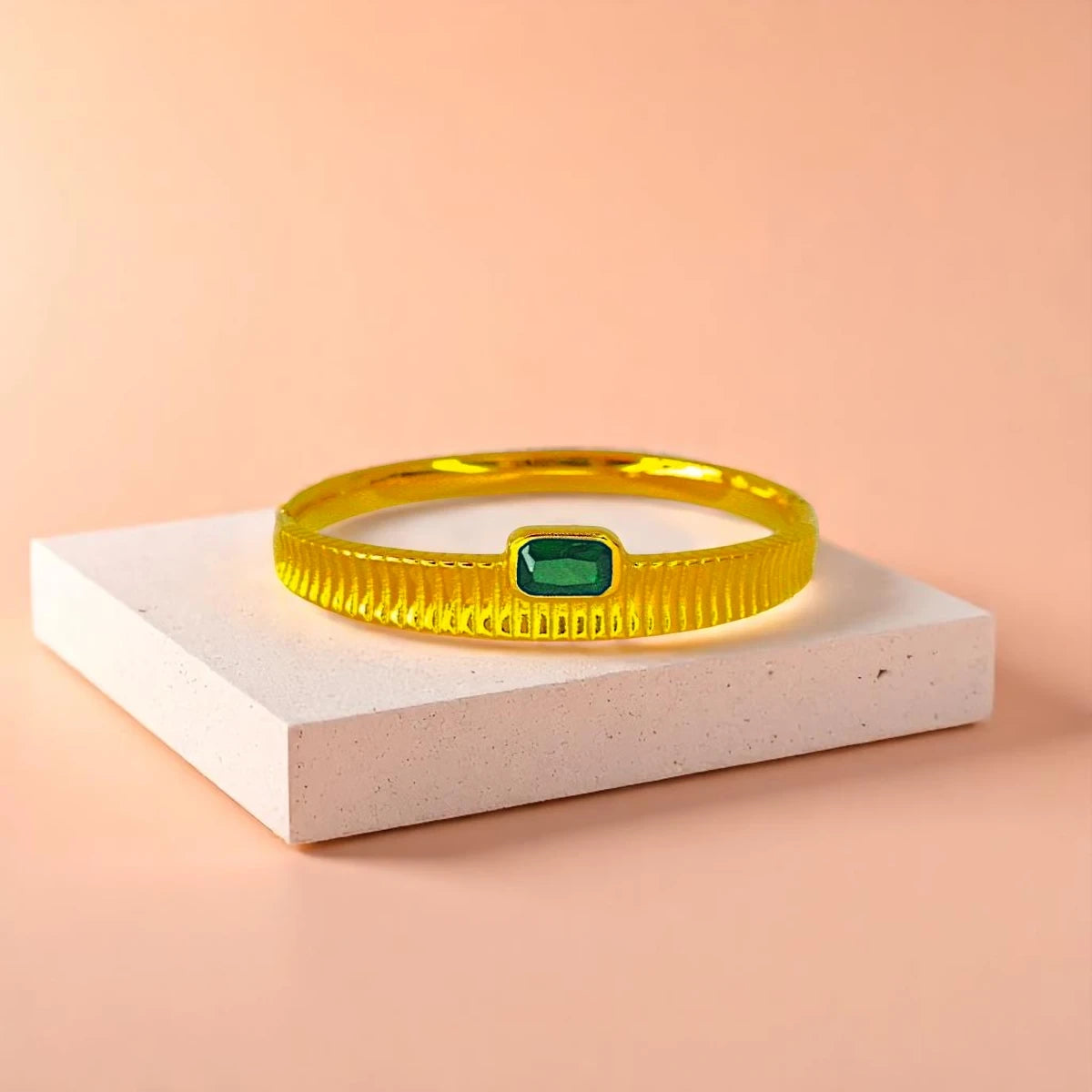 Bracelet displayed on a light-colored travertine stone slab with a peach-colored gradient in the background.