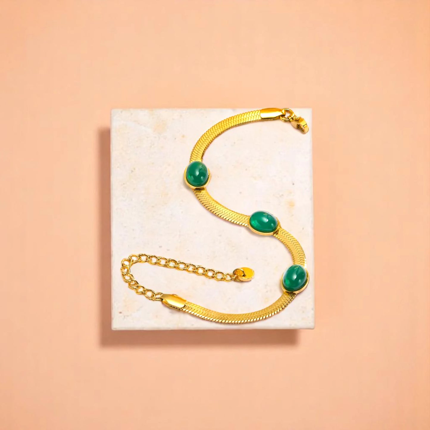 Bracelet on geometric prop with peach color gradient in the background.