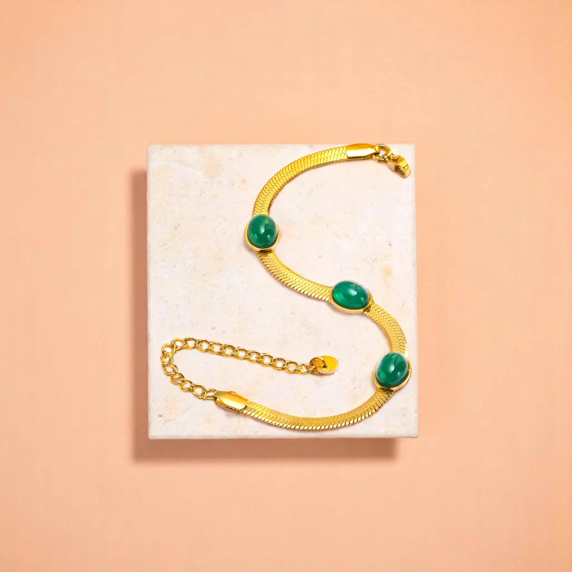 Bracelet on geometric prop with peach color gradient in the background.