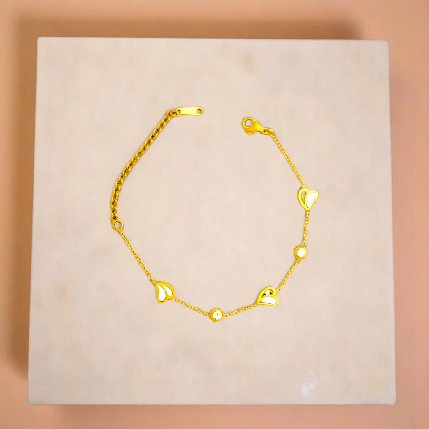 Bracelet on geometric prop with peach color gradient in the background.