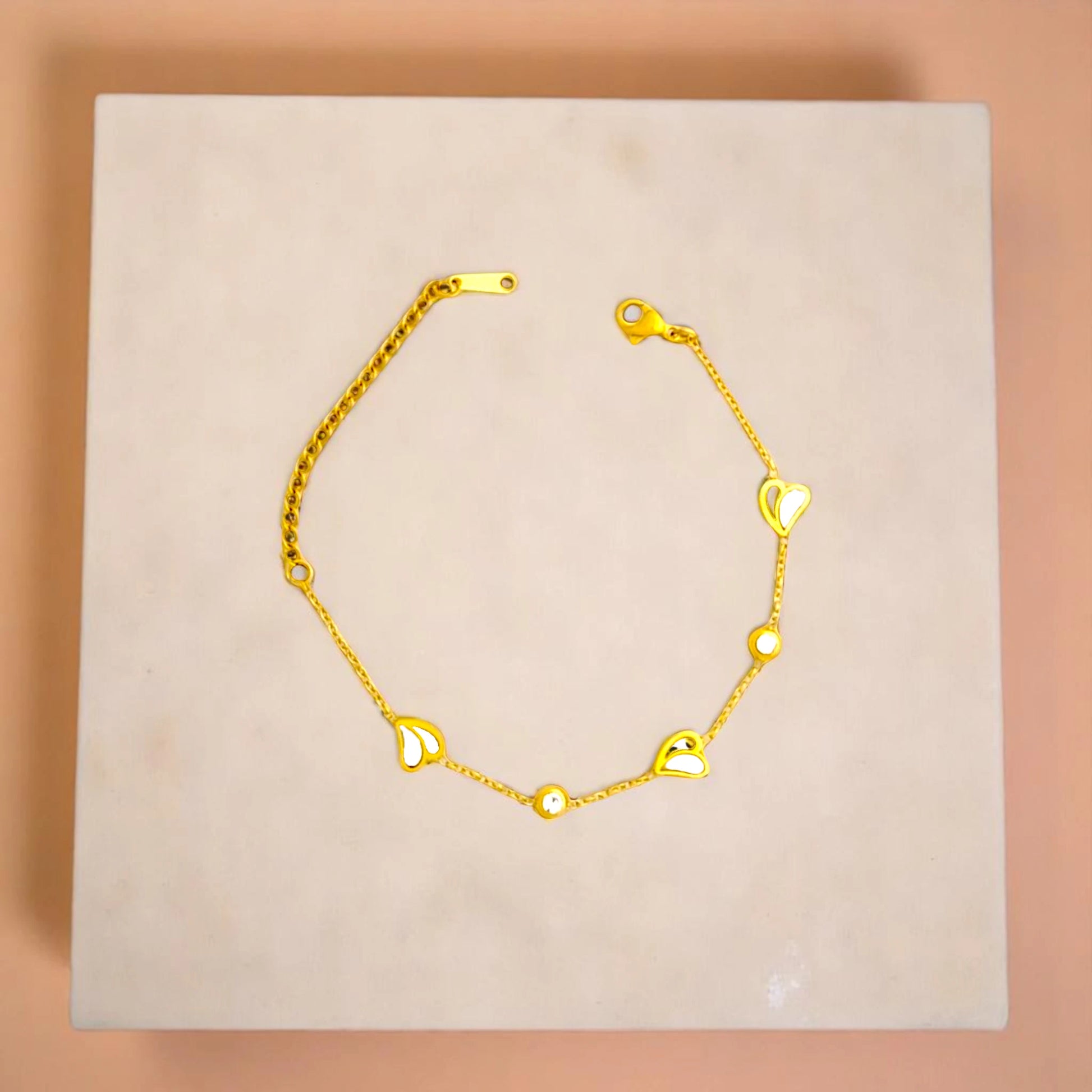 Bracelet on geometric prop with peach color gradient in the background.