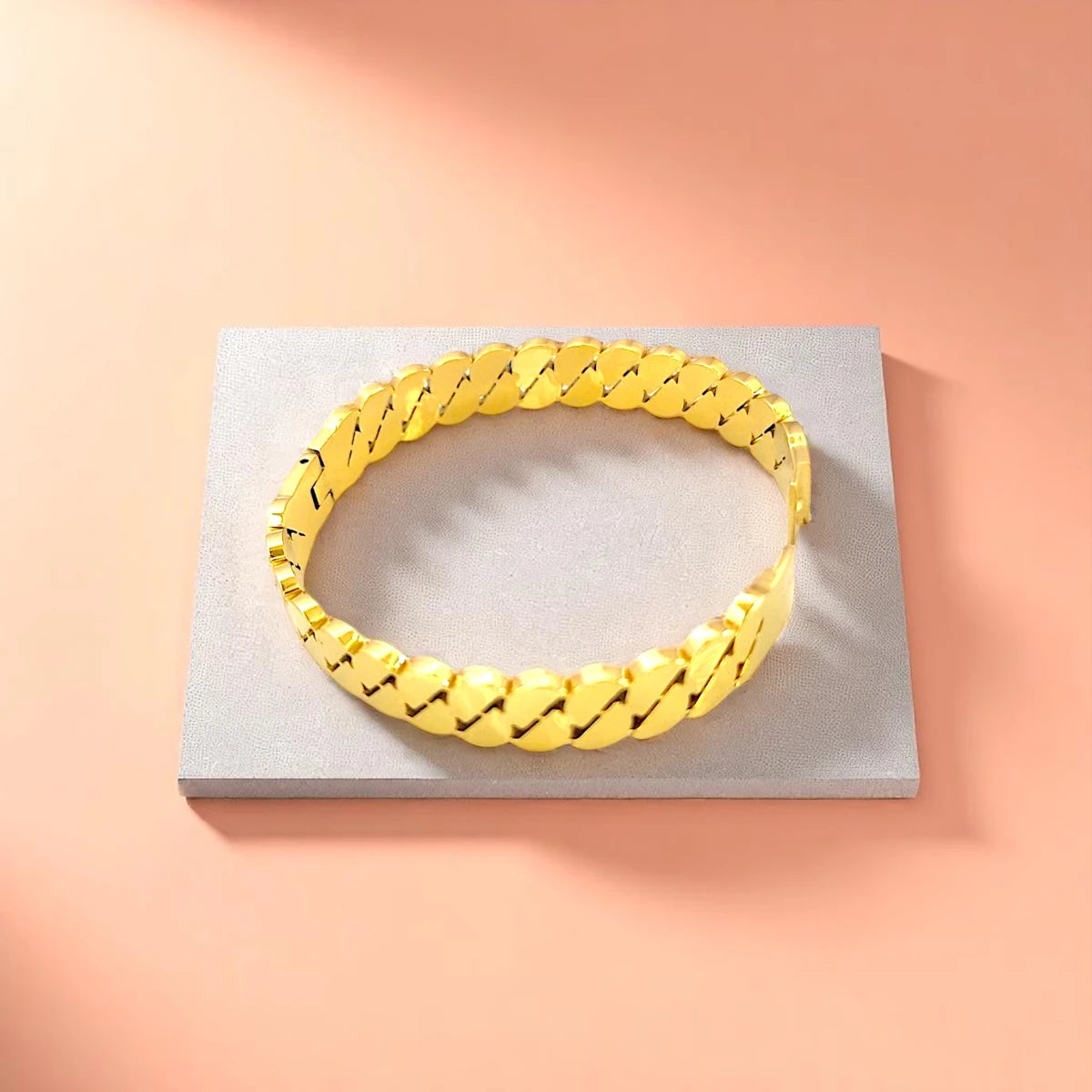 Bracelet displayed on a light-colored travertine stone slab with a peach-colored gradient in the background.