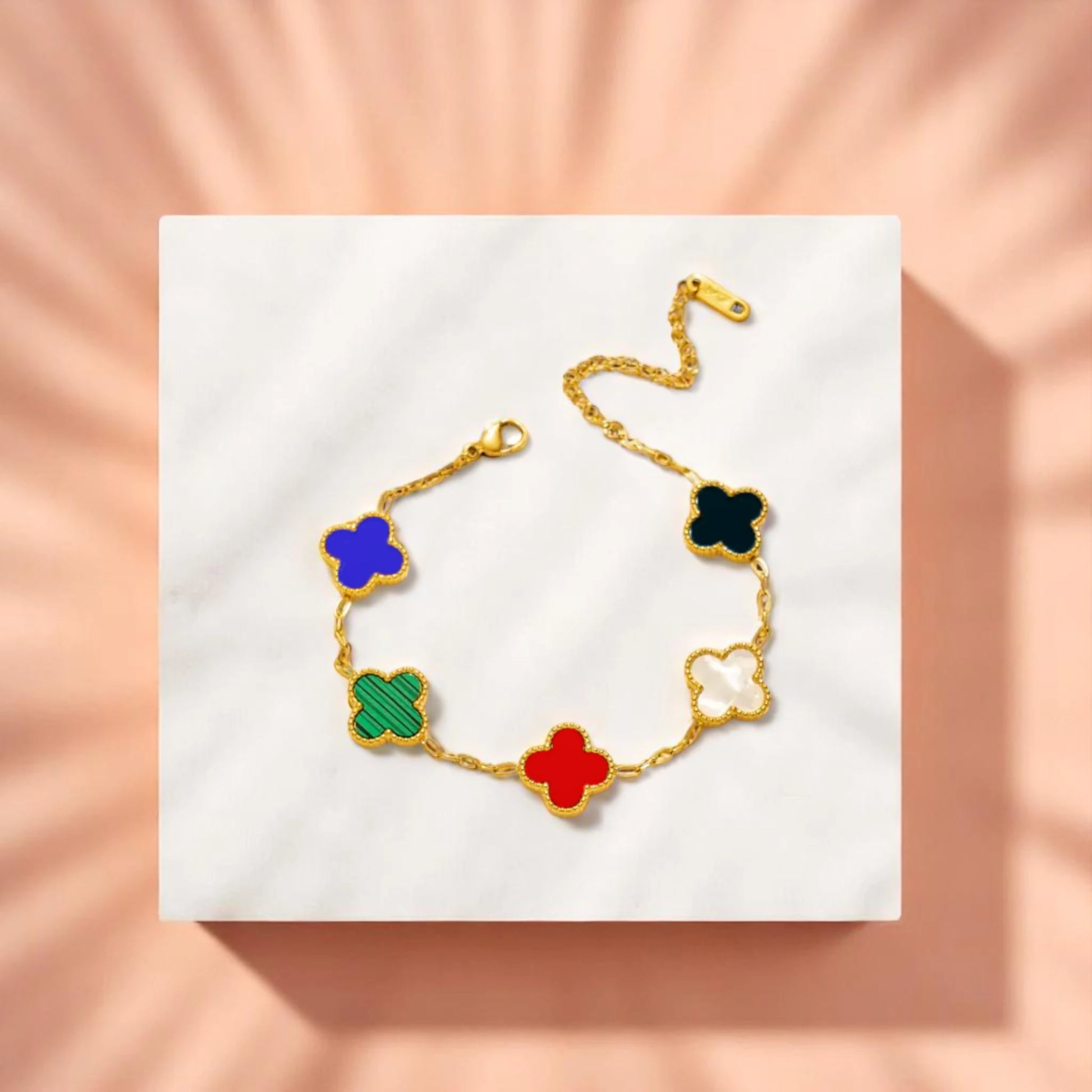 Bracelet on geometric prop with peach color gradient in the background.