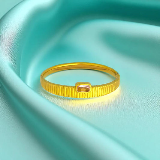 Bracelet set against a soft teal cloth background.