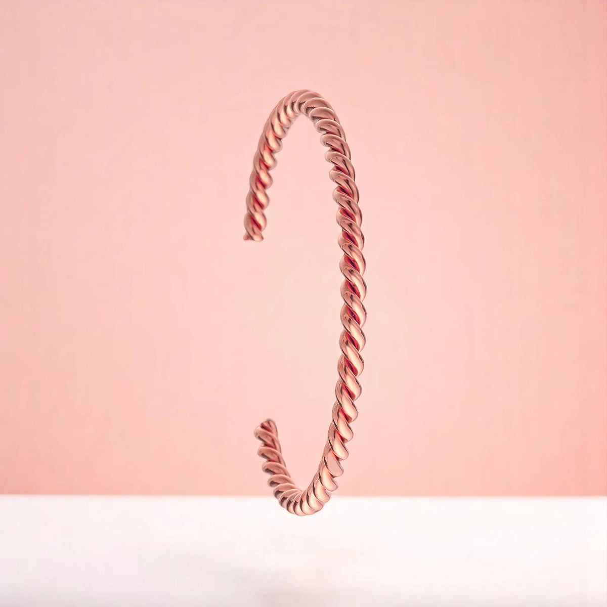 Bracelet on a color gradient of peach tones background.