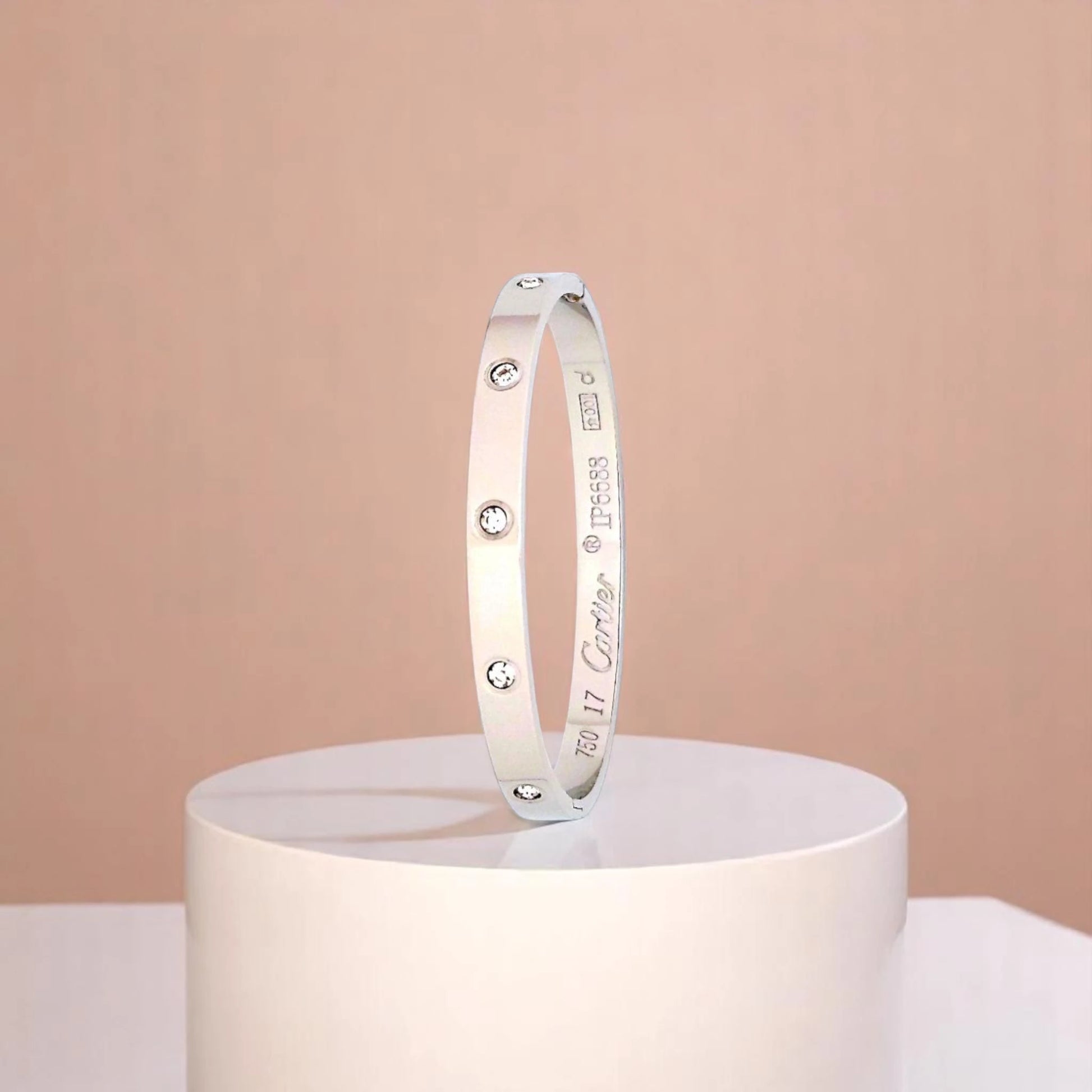 Bracelet on geometric prop with peach color gradient in the background.