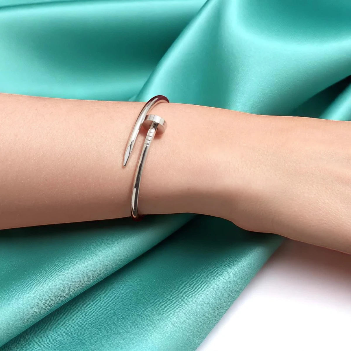 Bracelet worn by a model against a soft teal cloth background.
