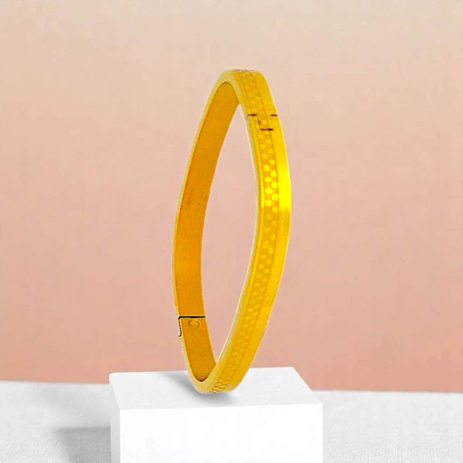 Bracelet on geometric prop with peach color gradient in the background.