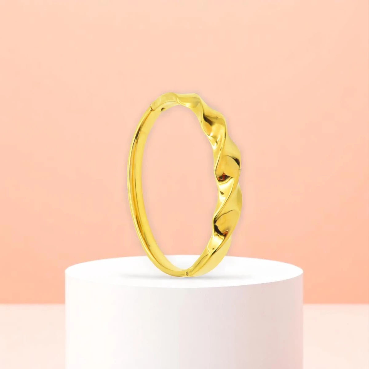 Bracelet displayed on a white pedestal against a soft peach background.
