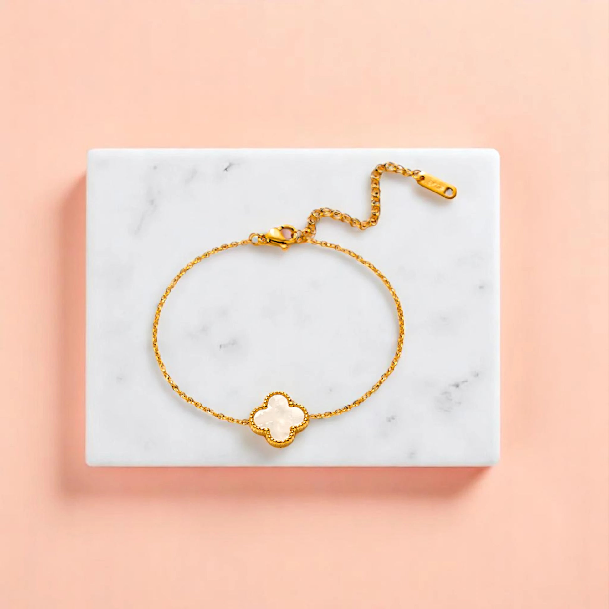 Bracelet on geometric prop with peach color gradient in the background.