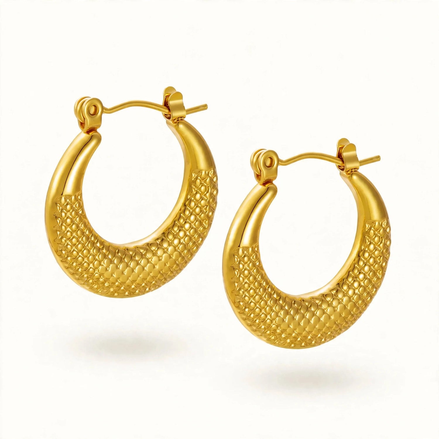 A pair of textured gold hoop earrings with a diamond-patterned finish and post-back closures, shown on a clean white background.