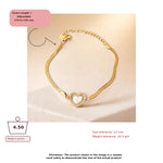 Gold adjustable chain bracelet with a heart-shaped mother-of-pearl centerpiece, shown on a beige background with size and weight information overlays.
