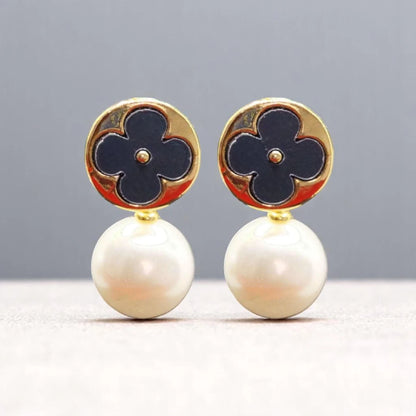 Elegant earrings featuring a gold circular top with a navy flower design, complemented by lustrous white pearl drops.