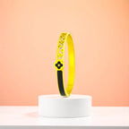 Bracelet displayed on a white pedestal against a soft peach background.