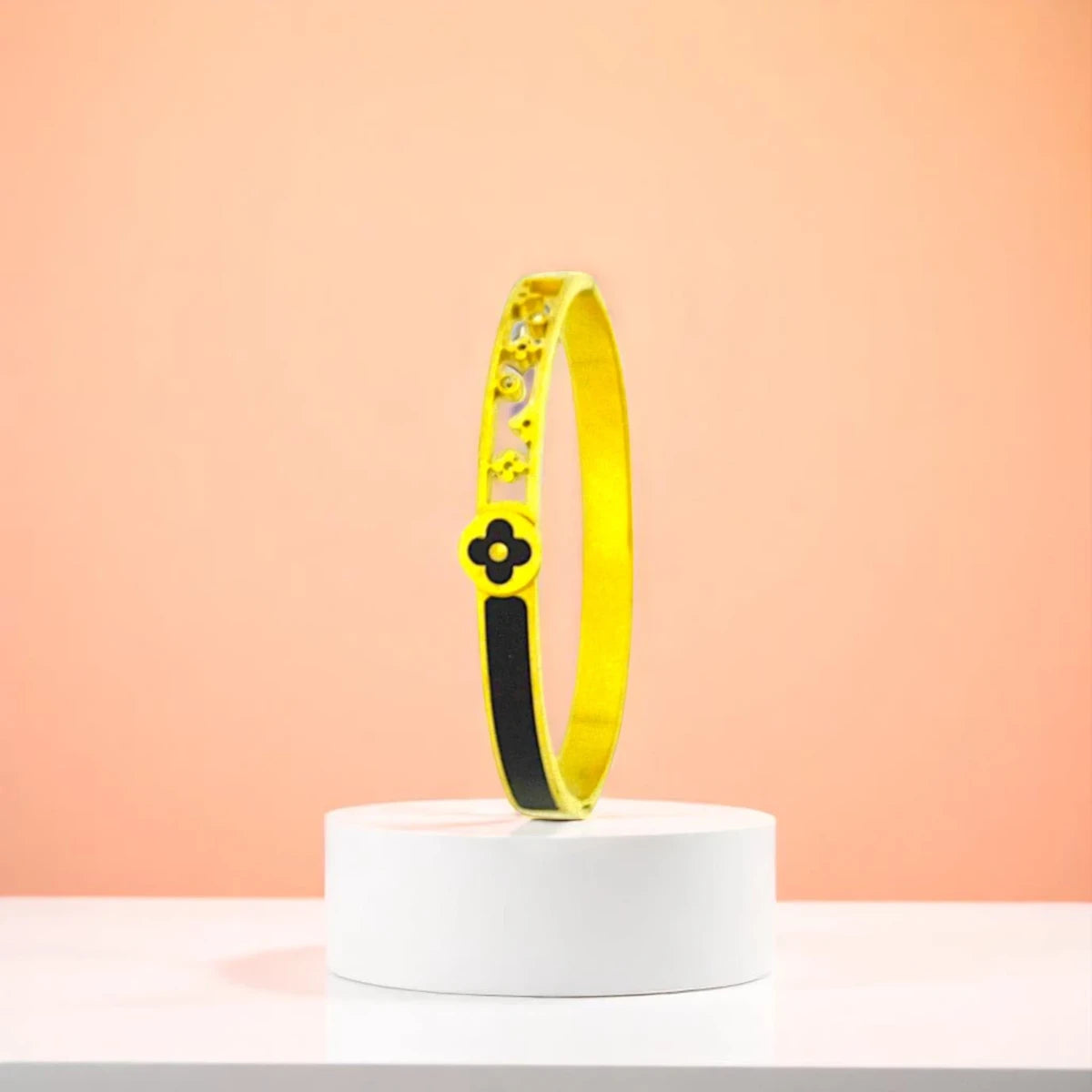 Bracelet displayed on a white pedestal against a soft peach background.