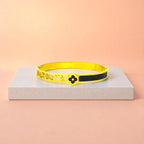 Bracelet displayed on a light-colored travertine stone slab with a peach-colored gradient in the background.