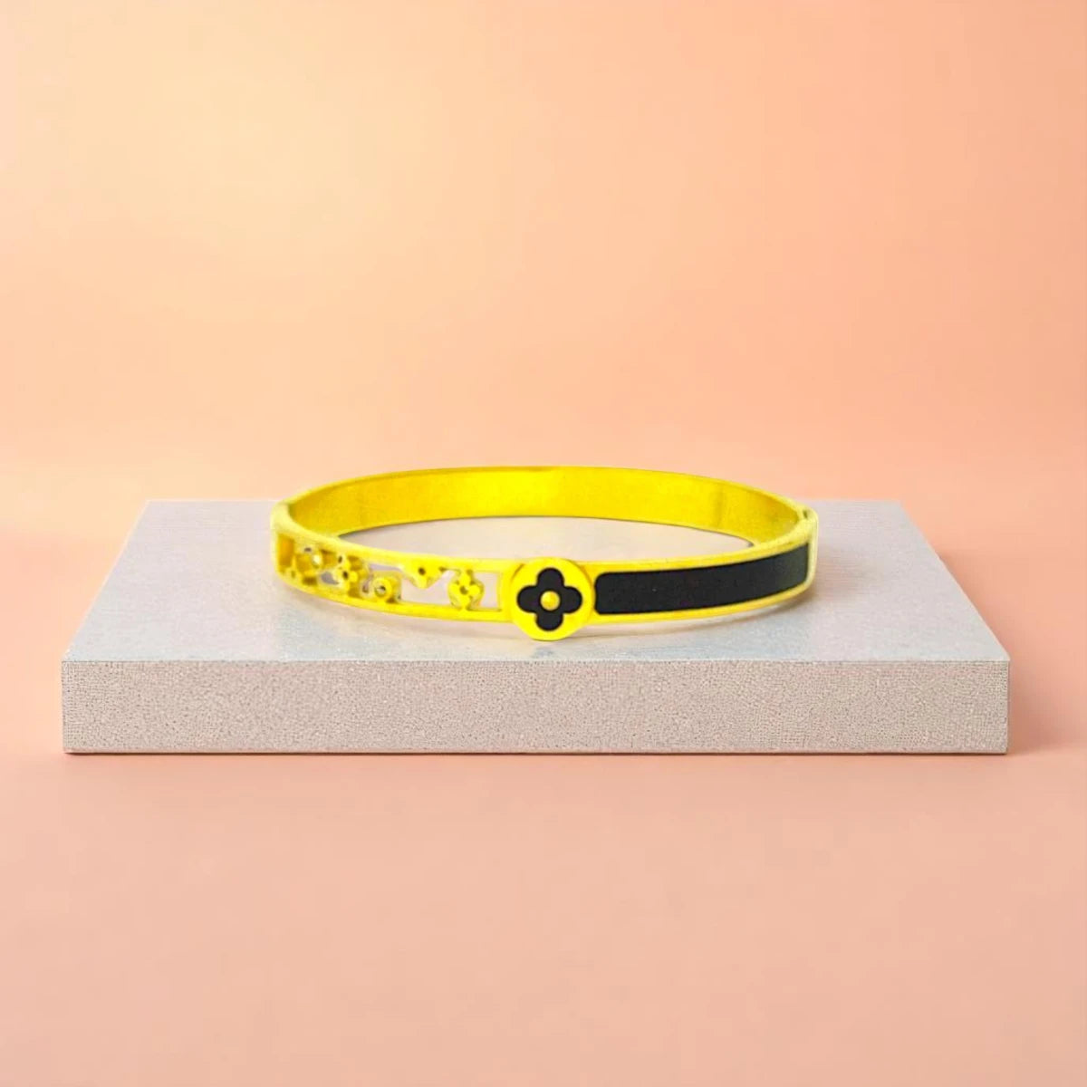 Bracelet displayed on a light-colored travertine stone slab with a peach-colored gradient in the background.