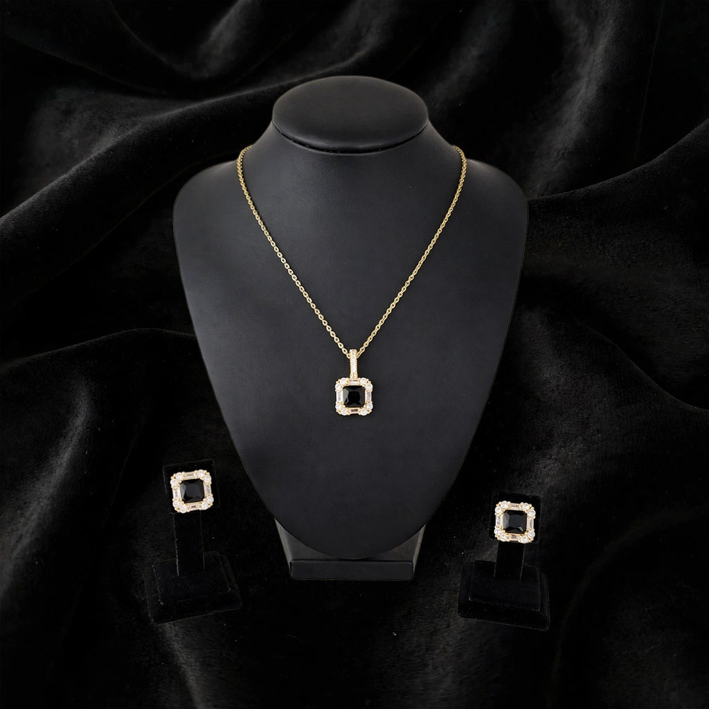 Gold square pendant necklace and matching stud earrings displayed on a black jewelry bust against a black velvet background.