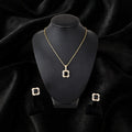 Gold square pendant necklace and matching stud earrings displayed on a black jewelry bust against a black velvet background.