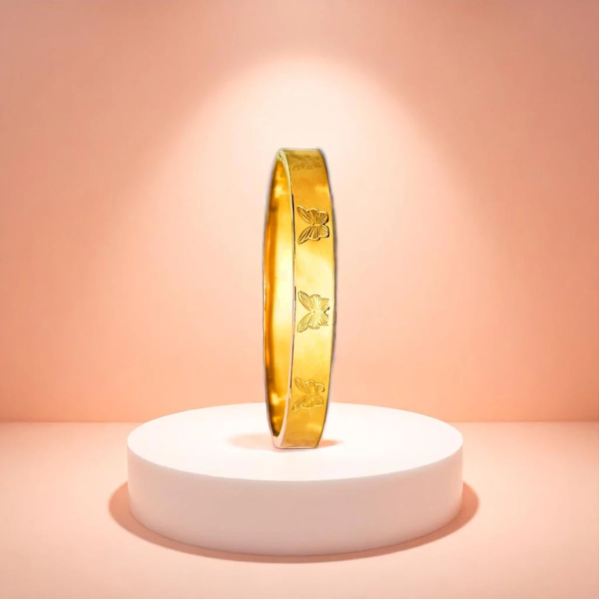 Bracelet displayed on a white pedestal against a soft peach background.