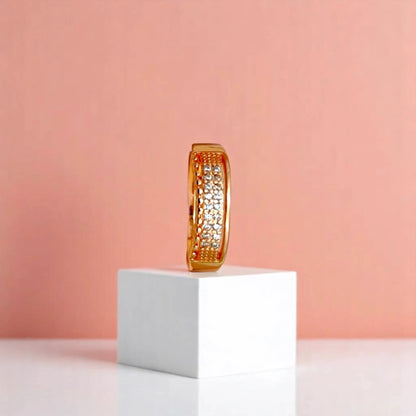 Ring on a white cube geometric prop with a peach color gradient in the background.