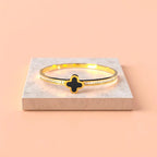 Bracelet displayed on a light-colored travertine stone slab with a peach-colored gradient in the background.