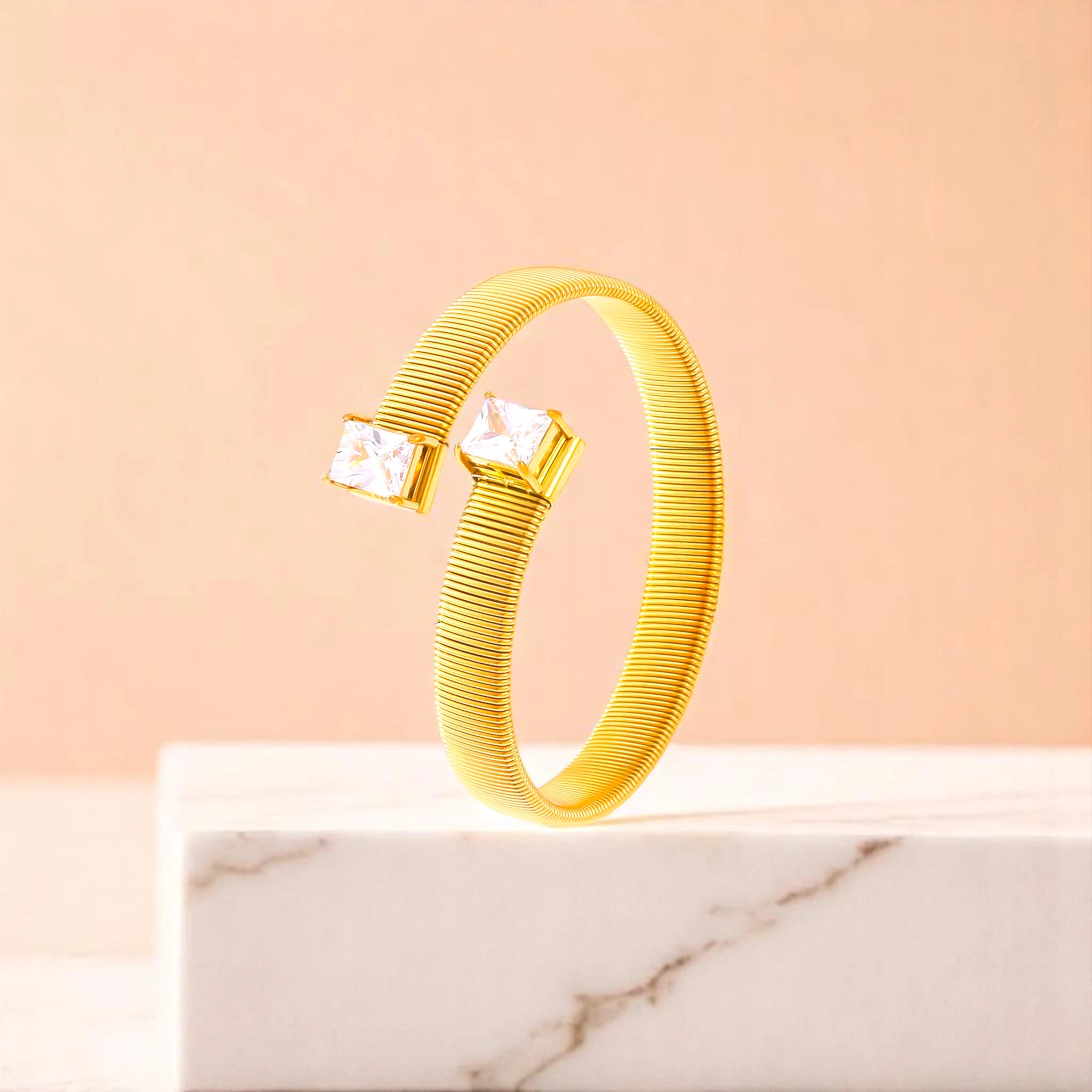 Bracelet on geometric prop with peach color gradient in the background.