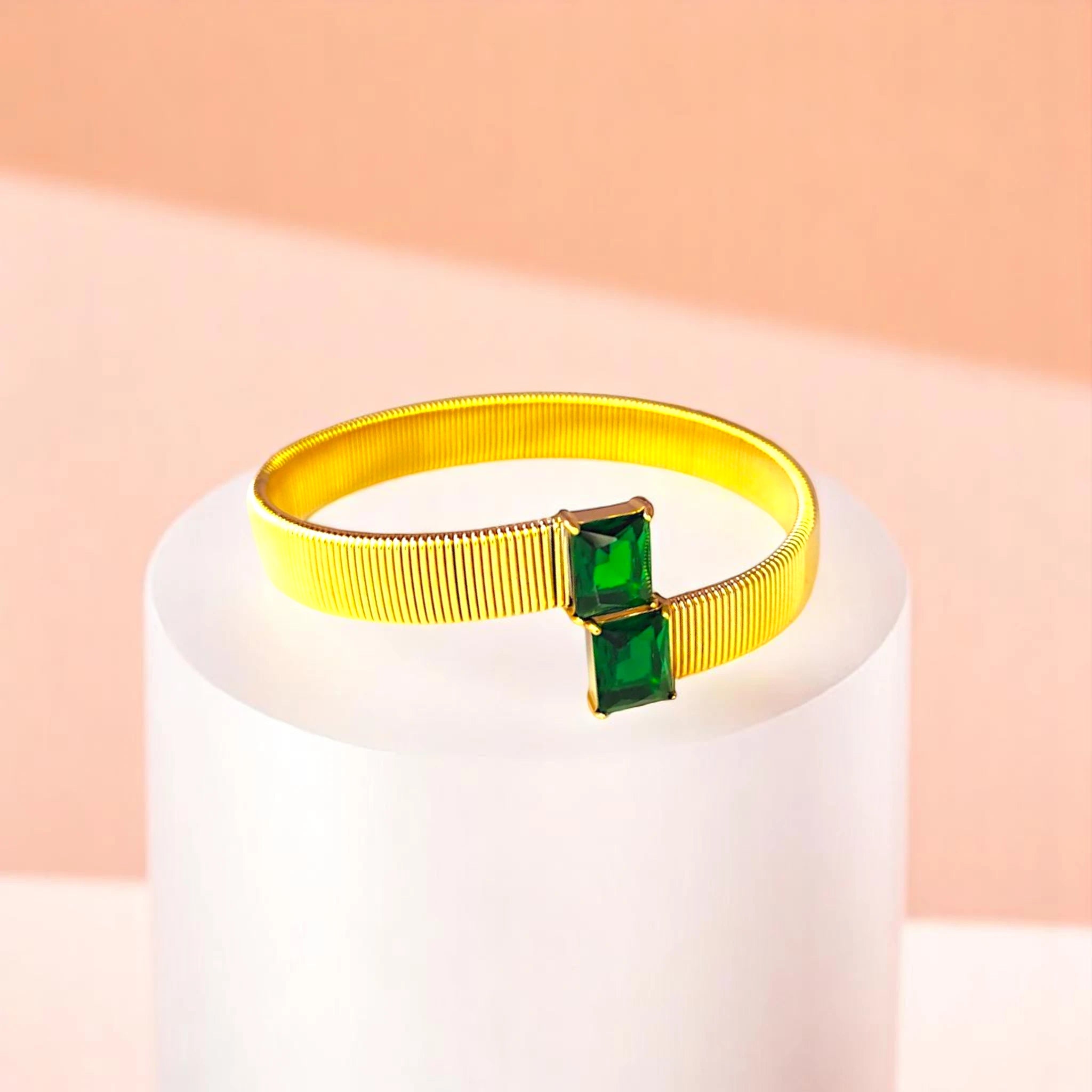 Bracelet on geometric prop with peach color gradient in the background.