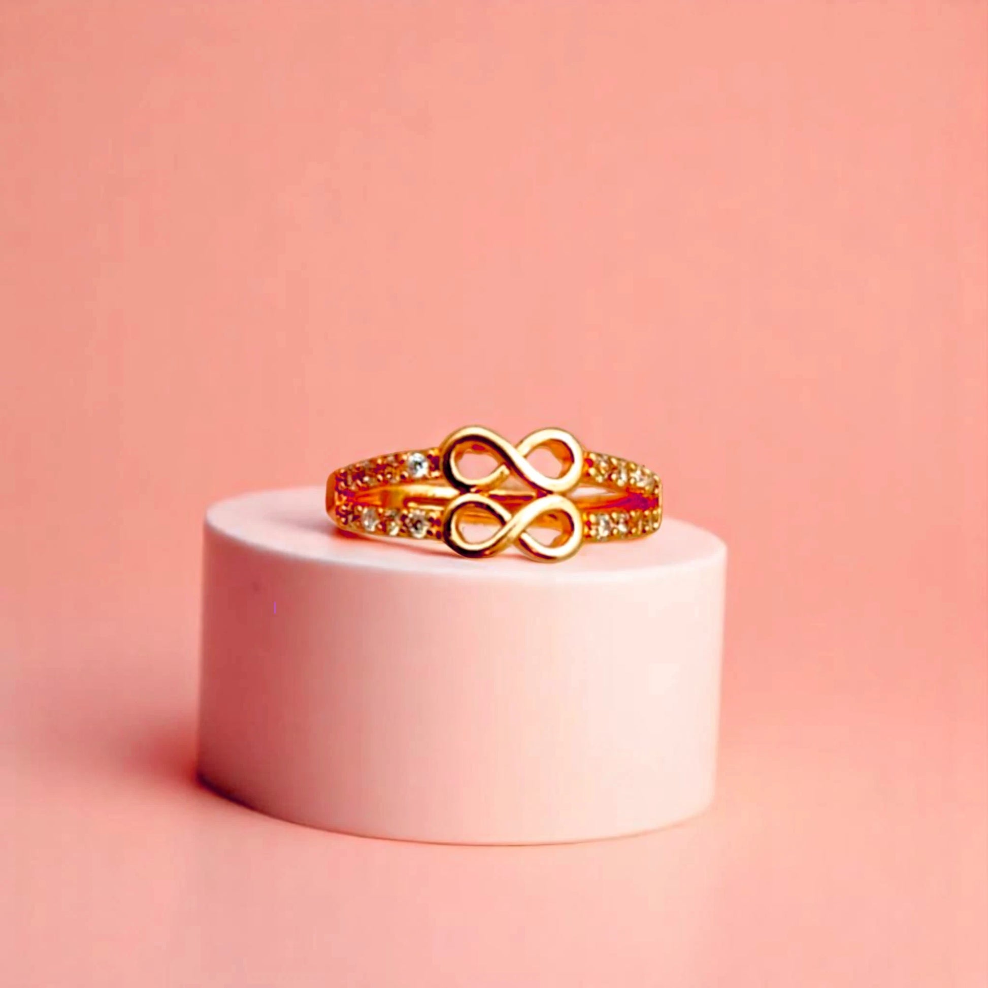 Ring on a white cylindrical geometric prop with a peach color gradient in the background.